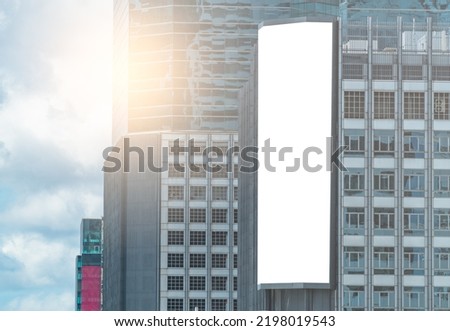 Big modern digital billboard on a high building, 3D empty a vertical digital billboard, blue sky background.