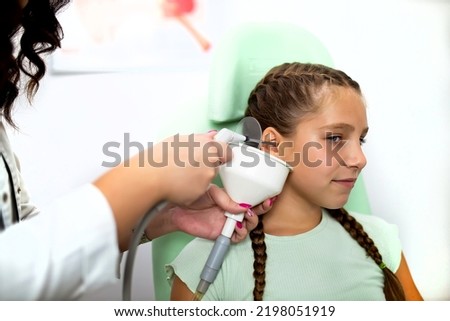 A woman doctor examines the ear of a patient in the ORL clinic.