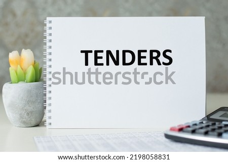 TENDER text is written on a notepad on an office desk, a business concept