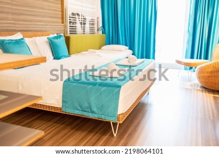 Interior of a modern bedroom with beautiful view. Bedroom interior design with white and blue pillows on bed and decorative.