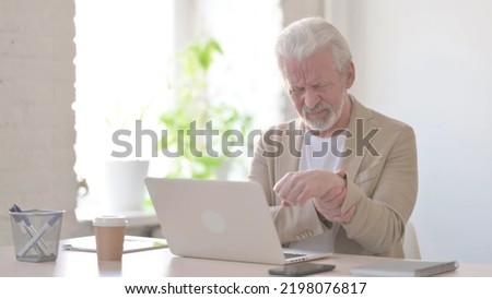 Old Man having Wrist Pain while using Laptop in Office