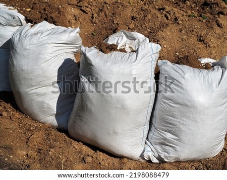 Sand pile and sandbags. A barricade wall made of sandbags. Protection against floods and landslides