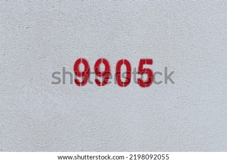 Red Number 9905 on the white wall. Spray paint.
