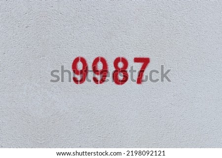 Red Number 9987 on the white wall. Spray paint.
