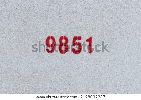 Red Number 9851 on the white wall. Spray paint.
