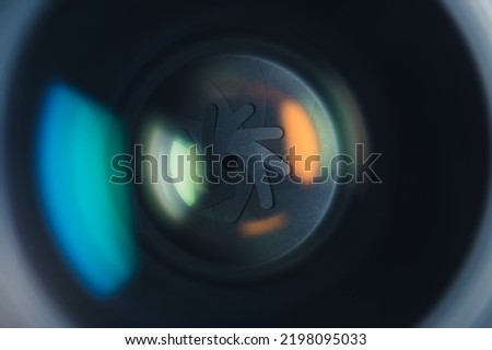 Close-up professional camera lens with color reflections. Aperture blades opening and closing during shooting. High quality photo
