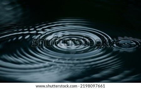 Water ripple or water drop splash on black background. Abstract shape out of the water Royalty-Free Stock Photo #2198097661
