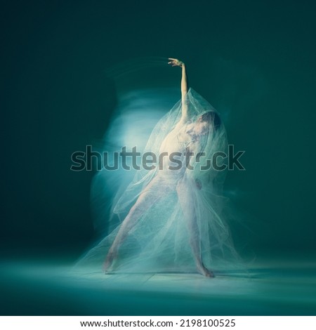 Modern art. Beautiful and graceful ballet dancer dancing with white transparent cloth isolated on cyan color background. Concept of beauty, action, flexibility and inspiration concept. Blurring effect Royalty-Free Stock Photo #2198100525