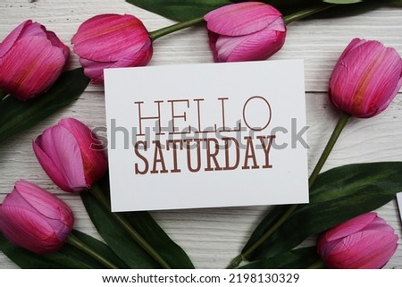 Hello Saturday card with tulip flower on wooden background