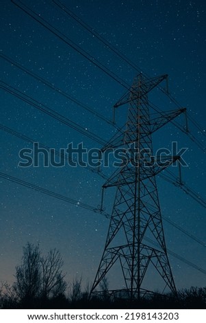 Newburn UK: March 2022: Looking up at electricity pylons on a clear starry night. Blue hour moody colours