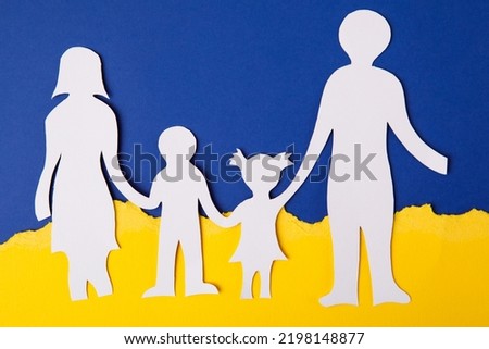The concept of the child of Ukraine dreams of peace with the family. paper-cut family painted in the national colors of Ukraine. Ukrainian flag