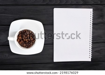 A view from above of a white blotter and a cup of coffee beans