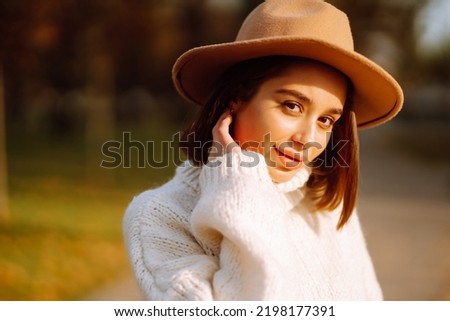 Stylish woman enjoying autumn weather outdoor. Fashion, style concept. People, lifestyle, relaxation and vacations concept. Royalty-Free Stock Photo #2198177391