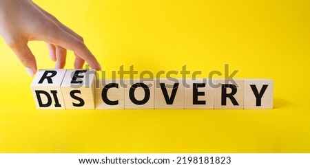 Recovery and Discovery. Businessman hand Turnes wooden cubes and changes word Discovery to Recovery. Beautiful yellow background. Business concept. Copy space