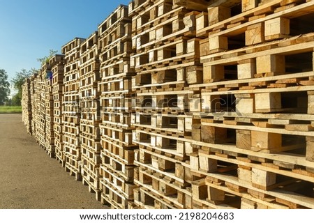 Stacks of wooden pallets in a warehouse yard of factory. Pallets for transportation of goods in a transport company.