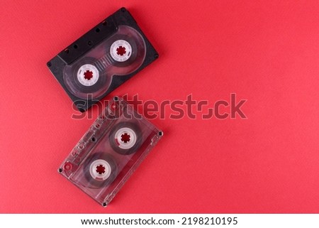 Red background with two old audio cassettes