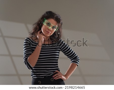 Sci-fi image of a young woman with glasses with information display on gray background