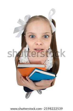 Happy cute child girl in school uniform holding books. Schoolgirl with facial expression isolated on white. Concept of education, reading, back to school.