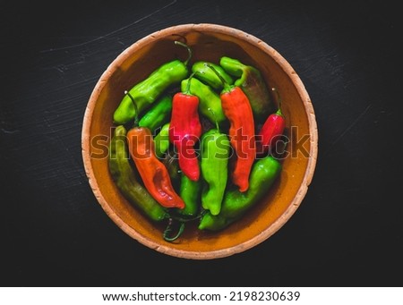 Pepperoncini peppers on a dark surface Royalty-Free Stock Photo #2198230639