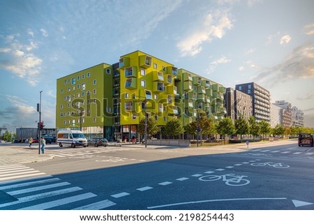 A modern residential building Ørestad plejecenter in bright light green color with windows and balconies in the form of cubes. Copenhagen, Denmark Royalty-Free Stock Photo #2198254443