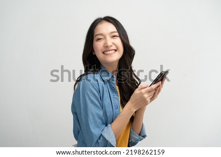 Happy Asian woman holding a smartphone and winning the prize. Royalty-Free Stock Photo #2198262159