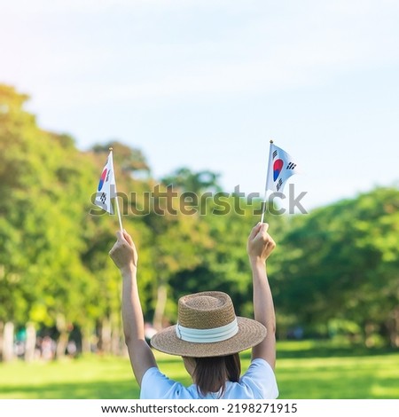 Woman hand holding Korea flag on nature background. National Foundation, Gaecheonjeol, public Nation holiday, National Liberation Day of Korea and happy celebration concepts Royalty-Free Stock Photo #2198271915