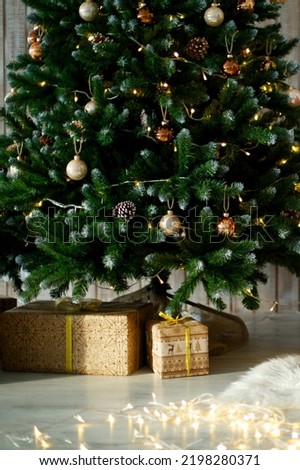 gifts on wooden floor, in gift boxes under christmas tree. Christmas or New Year background, backdrop