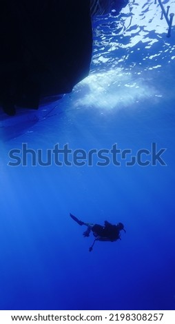 Underwater photo and art of scuba diver doing a descent in rays of sunlight. Royalty-Free Stock Photo #2198308257