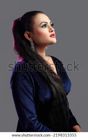 Beautiful young model girl looking up wear dark blue consume isolated on gray background     