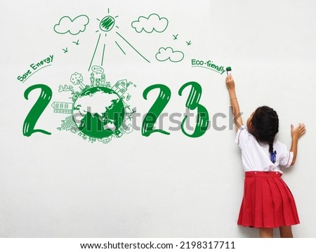 2023 new year Asian little girl holding a paint brush painting creative environmental and eco-friendly, Save energy on wall room
