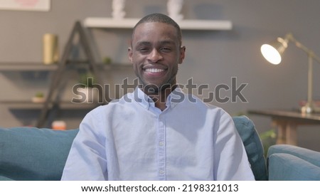 Portrait of African Man Showing Yes Sign while Sitting on Sofa