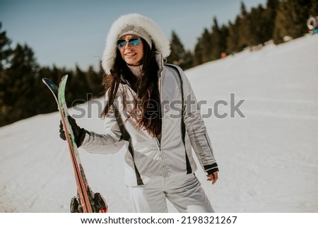 Young woman standing with skis on the ski track at a sunny day Royalty-Free Stock Photo #2198321267