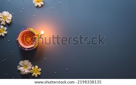 Happy Diwali - Clay Diya lamps lit during Diwali, Hindu festival of lights celebration. Colorful traditional oil lamp diya on blue background Royalty-Free Stock Photo #2198338135