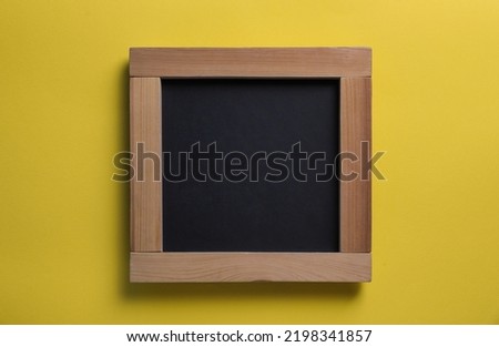 Blank chalkboard on yellow background, top view. Space for text