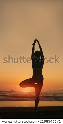 silhouette of Asian healthy woman is practicing yoga and meditation on beach in the dusk
