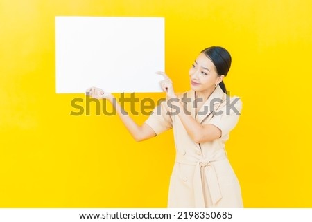 Portrait beautiful young asian woman with empty white billboard on color background