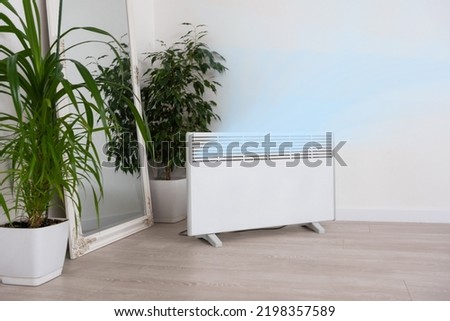 Modern electric infrared heater in living room Royalty-Free Stock Photo #2198357589