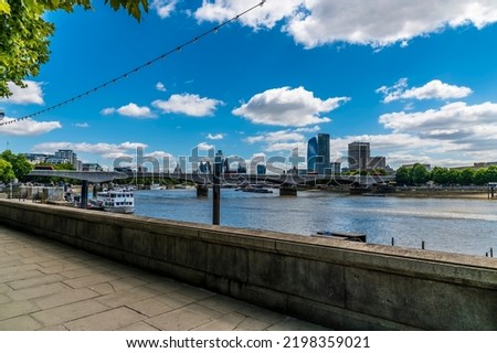 A view from the pavement of the Embankment along the River Thames towards Waterloo bridge in London, UK in summertime