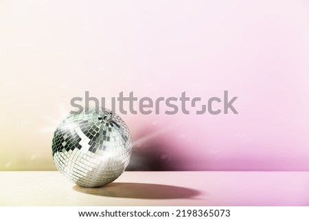 Disco ball on pink and yellow styled background. Disco floor, party, nightlife, going out concept. 