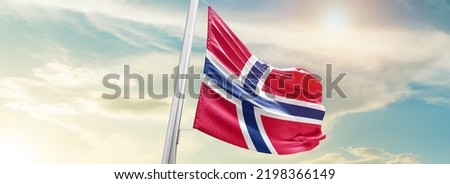 Norway national flag waving in beautiful sky. Royalty-Free Stock Photo #2198366149