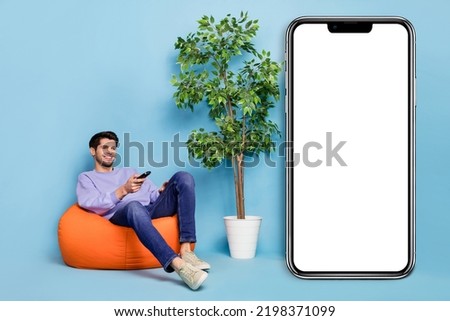Photo of guy enjoy free time sit bean chair poster watch series electronics commercial isolated pastel color background