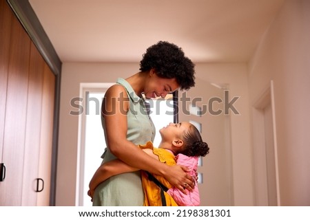 Daughter At Home Hugging Mother As She Helps Her To Get Ready For School Royalty-Free Stock Photo #2198381301