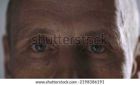 cropped view of middle aged man with wrinkles looking at camera isolated on grey