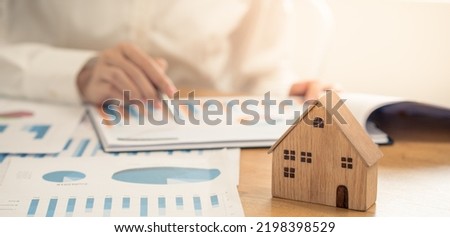 Hand Business calculating interest, taxes and profits to invest in real estate and home buying