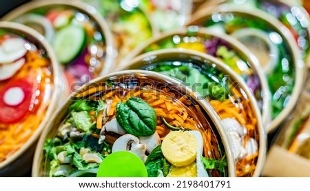Pre-packaged vegetable salads displayed in a commercial refrigerator Royalty-Free Stock Photo #2198401791