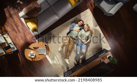 Top View Apartment: Young Couple in Love Lying on the Floor and Talking, Sharing their Dreams, Aspirations and Hopes. Girlfriend and Boyfriend Planning Brighter Future Together in a Cozy Living Room Royalty-Free Stock Photo #2198408985