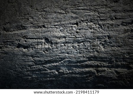 Darkened background of a black rock wall