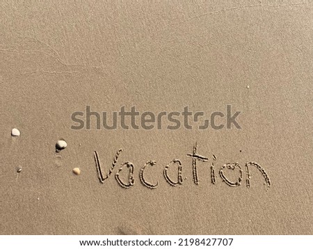 on the beach is carved with letters in the smooth sand the writing vacation