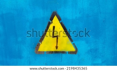 Bright yellow warning sign High voltage on blue background