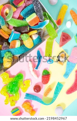 marmalade sweets, a background of various kinds of jelly sweets in the form of bears, ribbons, fruits and other toys. Candies in box. On a colorfull background.